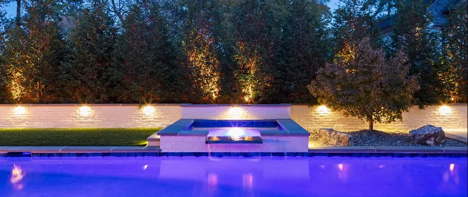 Outdoor lighting around a pool and some trees in Cary, NC.