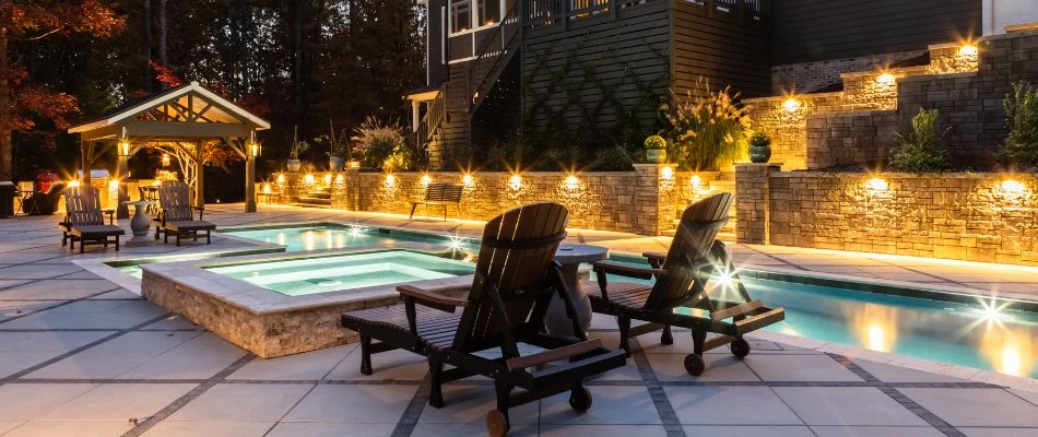 Retaining wall beside a pool in Cary, NC, with landscape lighting.