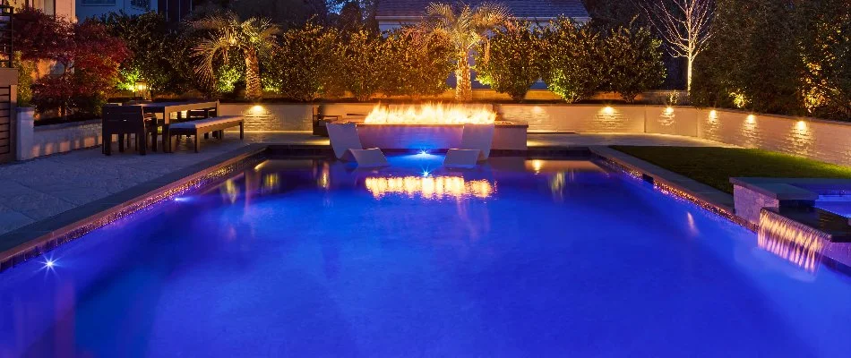 Fire pit beside a pool in Cary, NC, with lounge chairs.