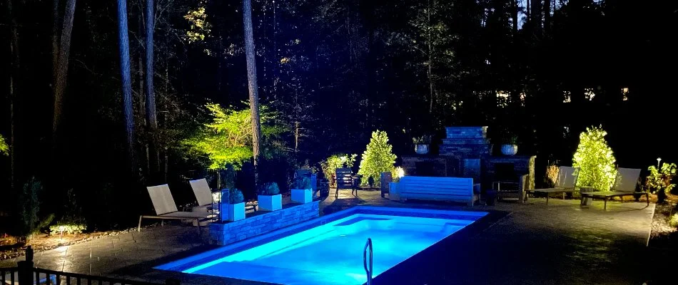 Pool at night with a fire pit next to it on a property in Gorman, NC.
