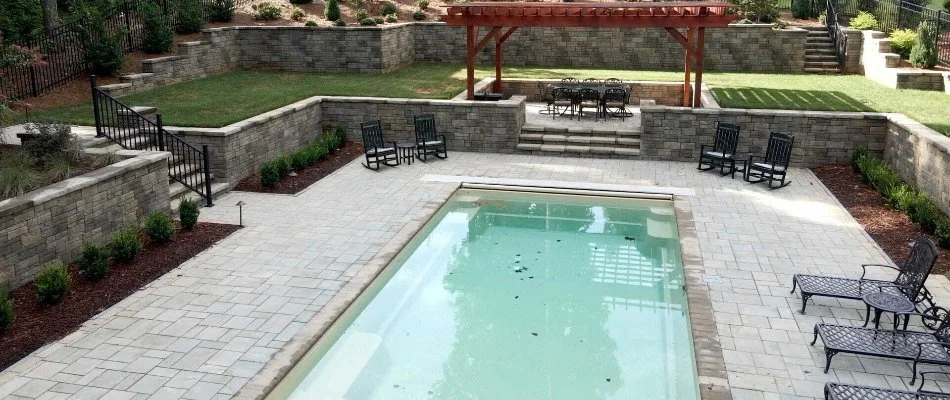 Paver patio around a pool in an outdoor space in Wendell, NC.