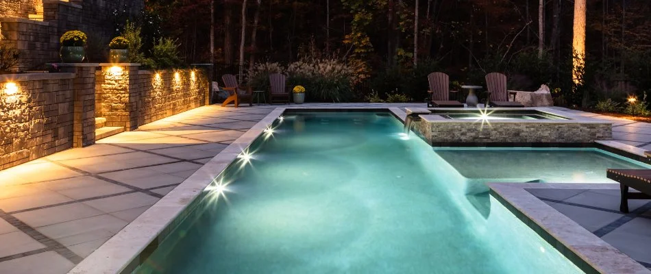 Swimming pool and hot tub at night on a property in Pittsboro, NC.