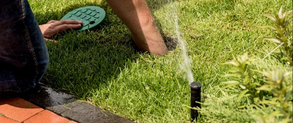 Professional repairing an irrigation system on a property in Cary, NC.