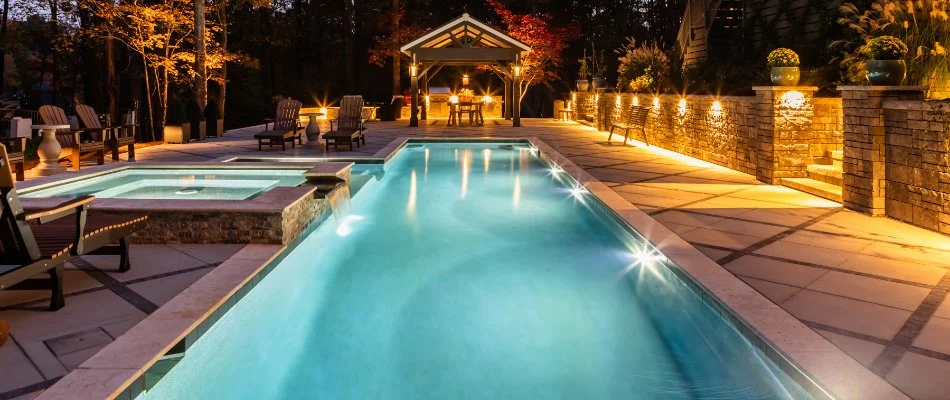 Rectangular pool, patio, and wall with lighting in Bethesda, NC.