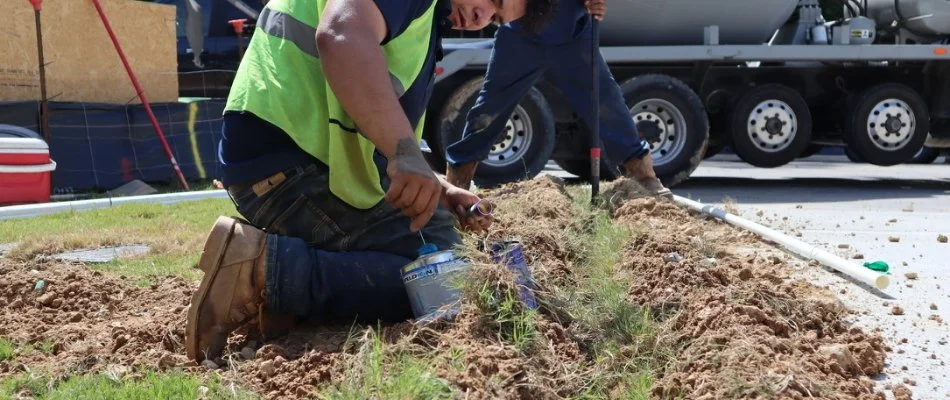 Techs placing a sprinkler in the ground in Durham County, NC.