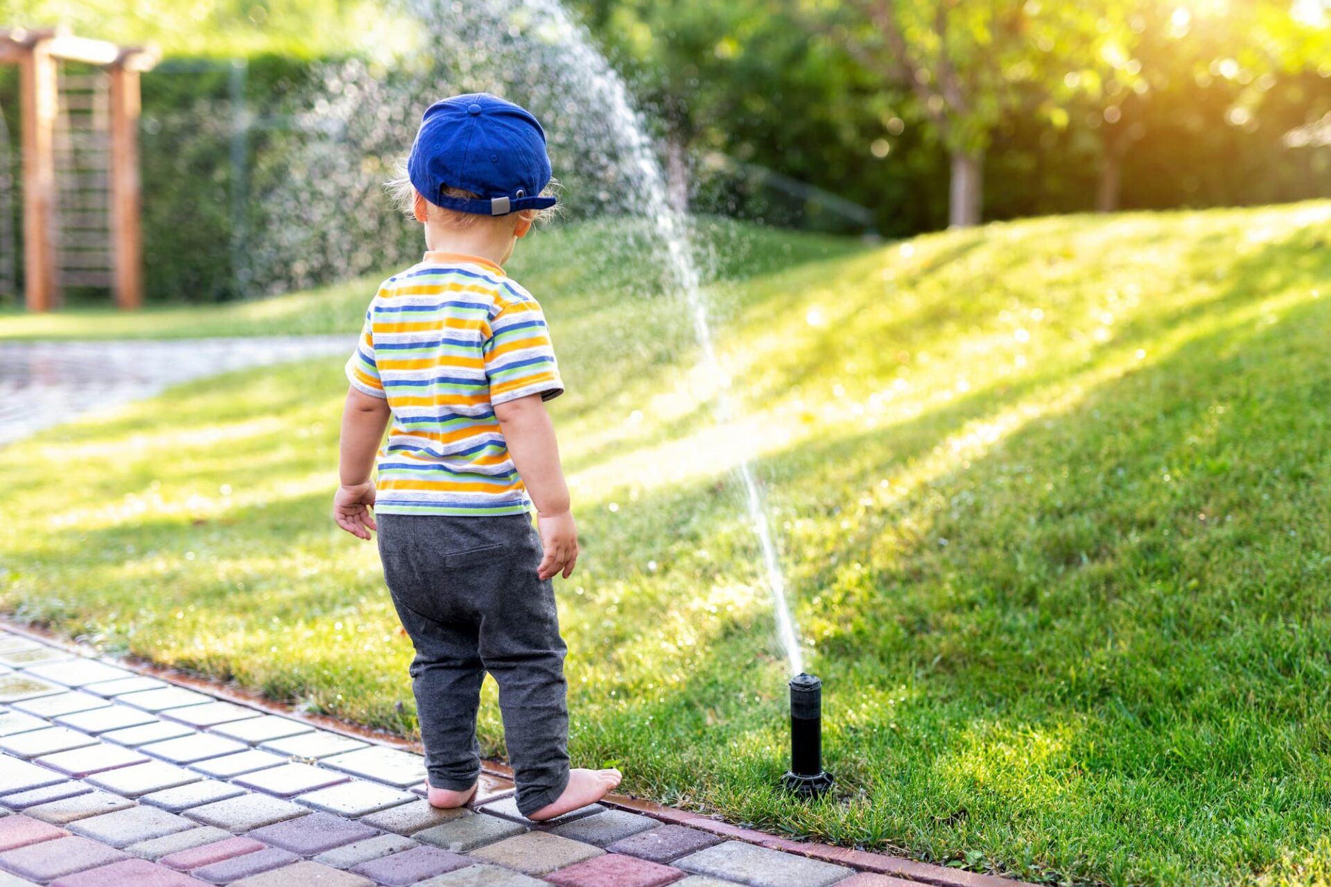 pricing-page-greenway-irrigation__child-playing-with-sprinklers